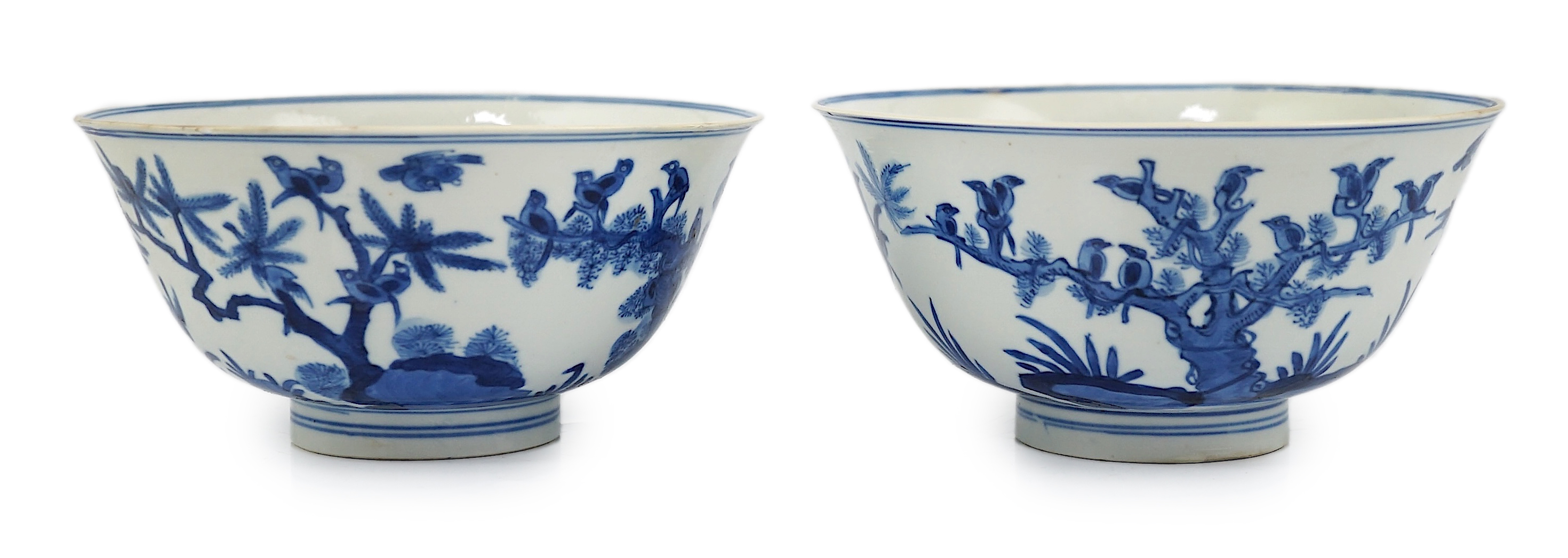 A near pair of Chinese blue and white ‘birds’ bowls, Kangxi period, one bowl restored